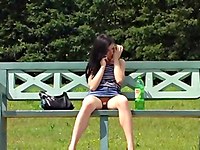 There is something sticking from the babes pussy as she is sitting on the bench showing nude upskirt